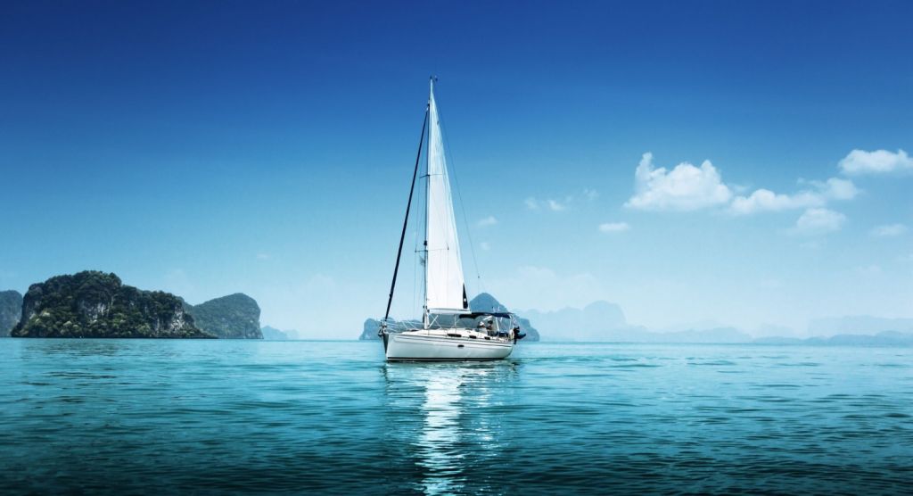 Lean sailboat in blue, protected waters with just the mainsail up
