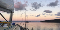Sailboat motoring at dawn